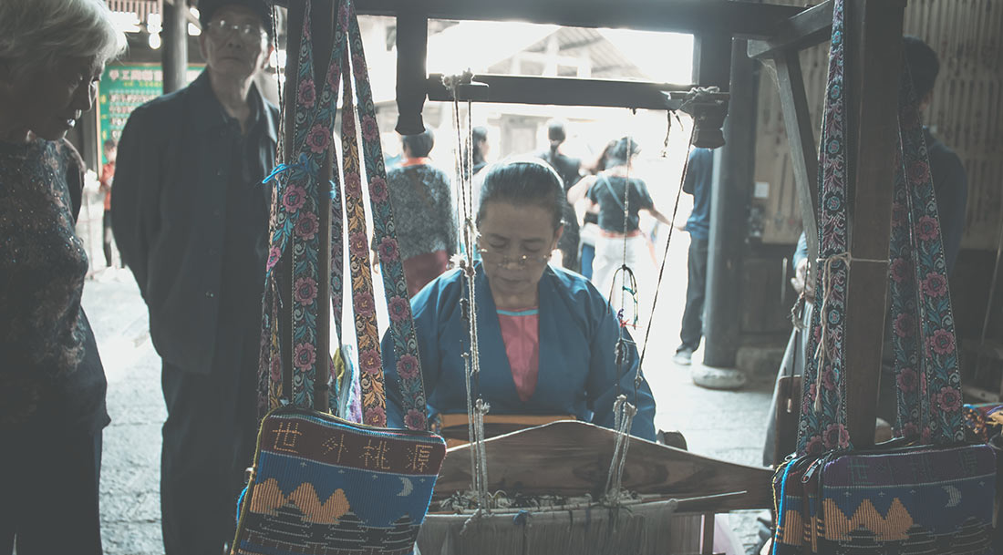 Chinese woman doing tipical craftwork with fabrics.